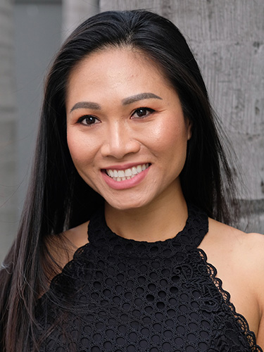 A picture of a woman wearing black top and a beautiful smile